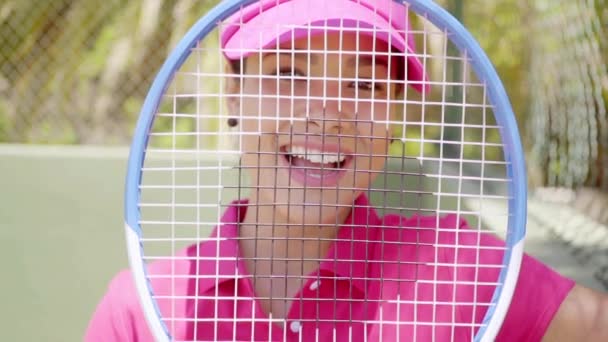 Jugador de tenis sonriendo a través de raqueta — Vídeos de Stock