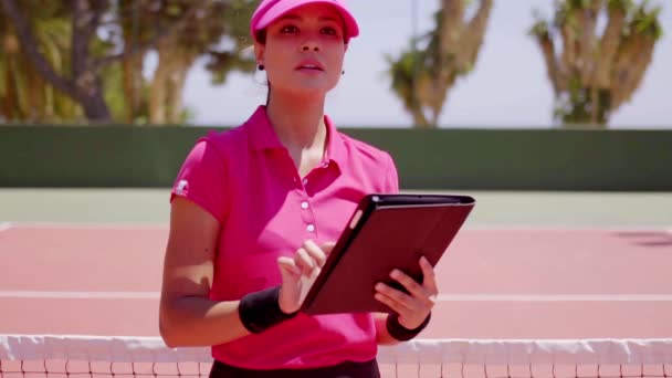 Mulher com tablet e raquete na rede de tênis — Vídeo de Stock