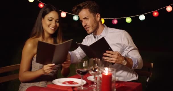 Lief jong koppel voedsel uit een menu kiezen — Stockvideo