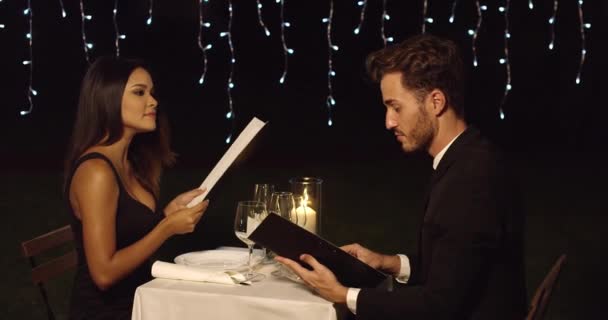 Jovem casal romântico lendo o menu — Vídeo de Stock