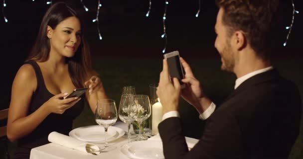 Man in suit takes photo of beautiful dinner date — Stock Video