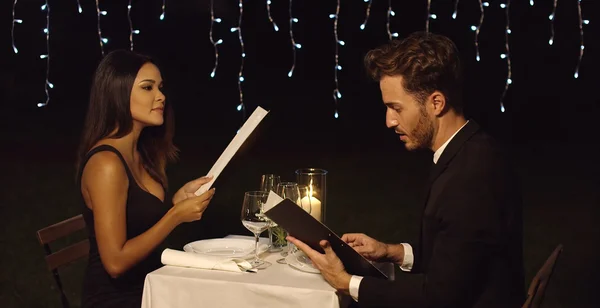Jovem casal romântico lendo o menu — Fotografia de Stock
