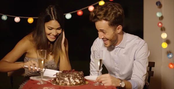 Pareja joven eufórica bromeando mientras cortan el pastel — Foto de Stock