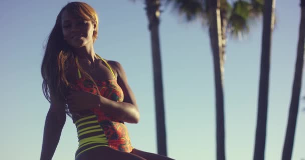 Молодая африканская женщина возле пальмы — стоковое видео