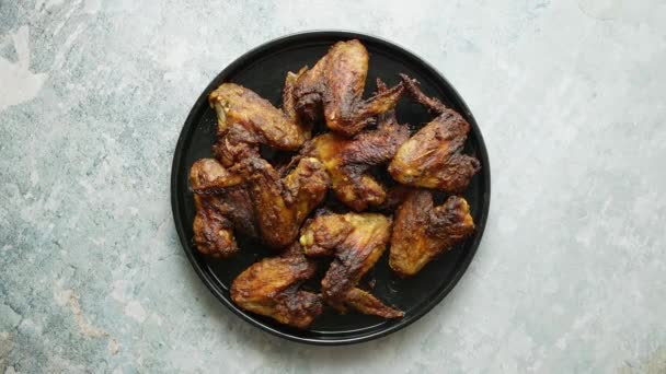 Alitas de pollo a la parrilla en un plato de cerámica negra. Colocado en una piedra — Vídeos de Stock