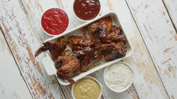 Ailes de poulet en sauce barbecue épaisse avec diverses trempettes latérales. Servi sur plat en fonte blanche — Video