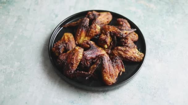 Gegrillte Chicken Wings auf einer schwarzen Keramikteller. Auf einen Stein gelegt — Stockvideo