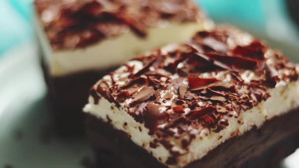 Cerrar en trozos de chocolate de la torta en capas. Espolvoreado con chocolate con leche — Vídeos de Stock
