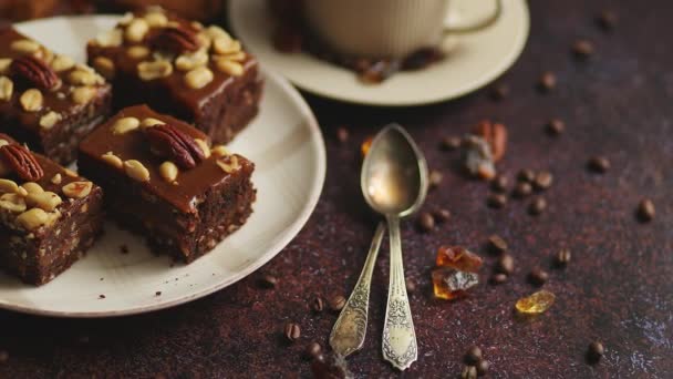 Schokoladenkuchen mit Karamell-Zuckerguss, Pekannüssen und heißem Kaffee auf rustikalem Hintergrund. Frisch gebacken — Stockvideo