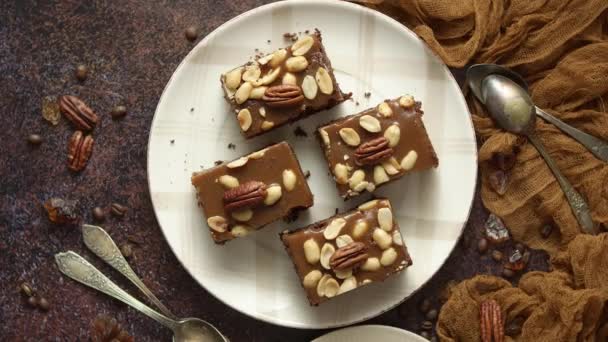 Pastel de chocolate con glaseado de caramelo, nueces y café caliente, sobre fondo rústico. Recién horneado — Vídeos de Stock