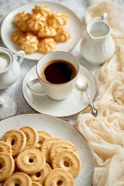 Vista lateral del delicioso postre servido. Galletas de mantequilla y coco con taza de café negro — Foto de Stock