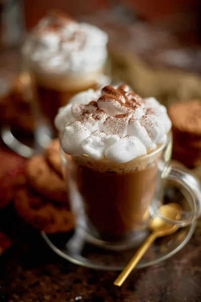 Dois copos altos com chocolate quente, chantilly e canela em pó em cima — Fotografia de Stock