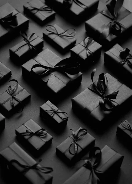 Elégant thème de Noël noir. Cadeaux enveloppés en papier mat noir avec ruban — Photo