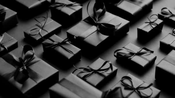 Elegancki czarny motyw świąteczny. Zapakowane prezenty w czarny matowy papier ze wstążką — Wideo stockowe