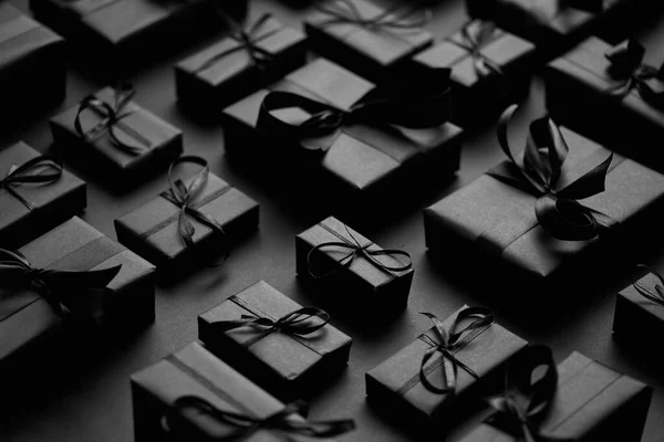 Elégant thème de Noël noir. Cadeaux enveloppés en papier mat noir avec ruban — Photo