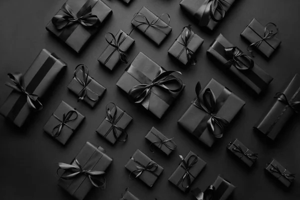 Elégant thème de Noël noir. Cadeaux enveloppés en papier mat noir avec ruban — Photo