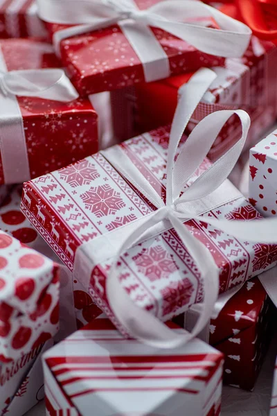 Kerstconcept. Close-up op feestelijk papier verpakt geschenken met lint — Stockfoto