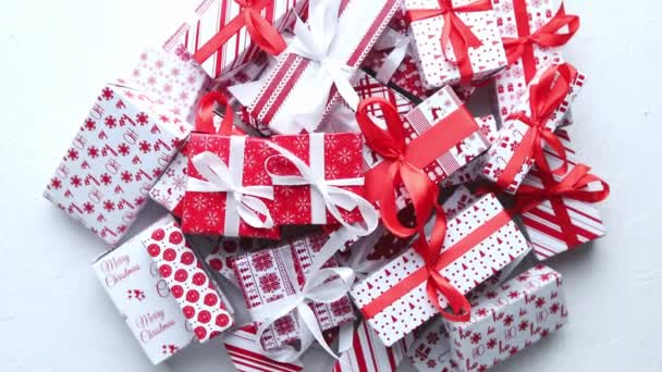 Ein Stapel verschieden großer, in festliches Papier verpackter Geschenke, die auf Stapel gelegt wurden. Weihnachtskonzept — Stockvideo