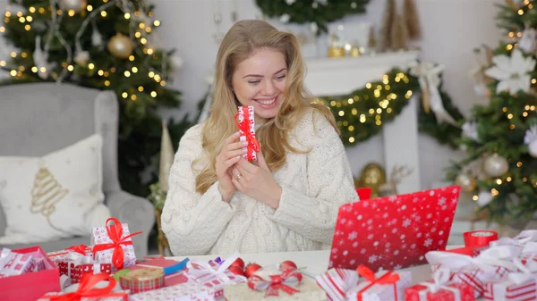 Щаслива молода жінка має відеочат на ноутбуці в різдвяній прикрашеній вітальні — стокове фото