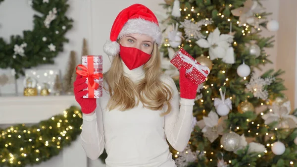 Ritratto di una bella donna col cappello di Natale. La donna indossa la maschera protettiva dal virus — Foto Stock