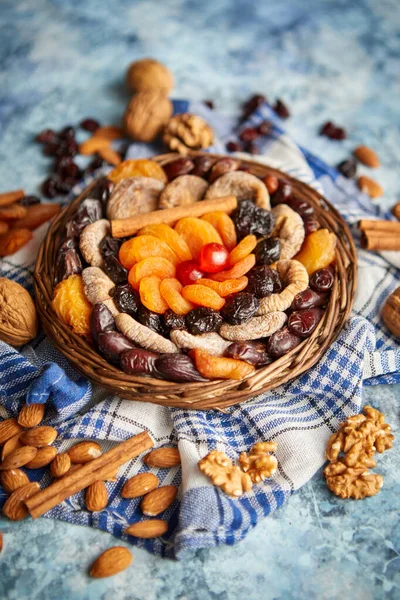 Samenstelling van gedroogde vruchten en noten in kleine rieten schaal geplaatst op stenen tafel — Stockfoto