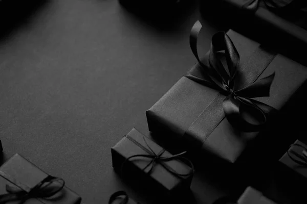 Una pila de varios tamaños de regalos en caja negra colocados en la pila. Concepto de Navidad. —  Fotos de Stock