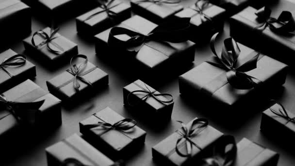 Элегантная чёрная рождественская тема. Завернутые подарки в черную матовую бумагу с лентой — стоковое видео