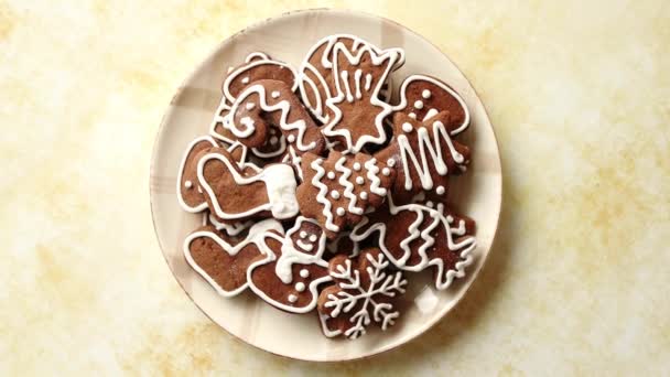 Пряничное печенье в различных рождественских тематических формах на тарелке — стоковое видео