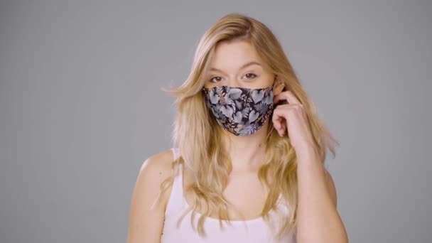 Innholdskvinne tar av maske og ser på kamera – stockvideo