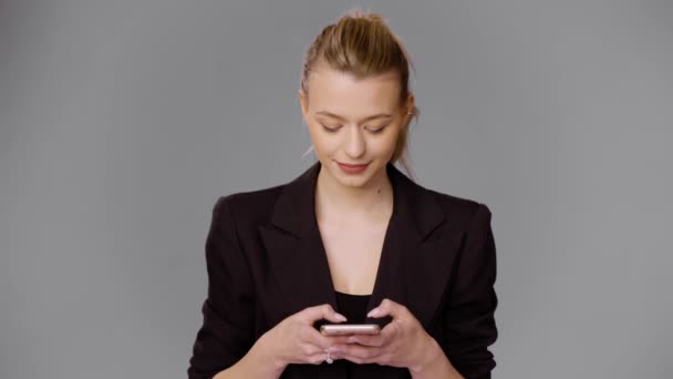 Elegante mujer de negocios navegando teléfono inteligente en el estudio — Vídeos de Stock