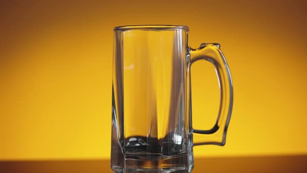 Colpo al rallentatore di bicchiere di birra vuoto su sfondo arancione — Video Stock