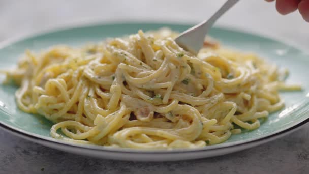 Sluiten op verse spaghetti carbonara op bord. Noedels worden op een vork gerold — Stockvideo