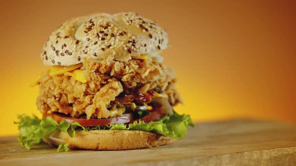 Sabrosa hamburguesa de pollo crujiente al fuego con queso cheddar, lechuga, tomate y cebolla — Vídeos de Stock