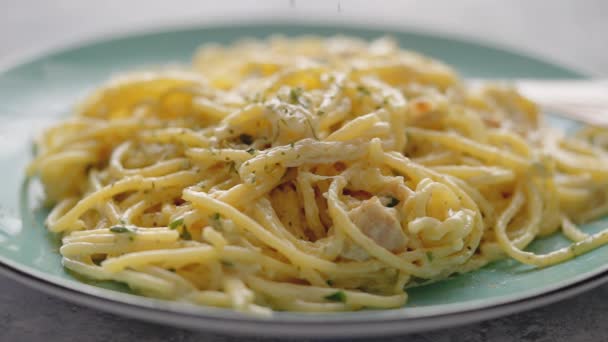 Close-up op verse spaghetti carbonara op bord dat wordt bestrooid met gedroogde peterselie — Stockvideo
