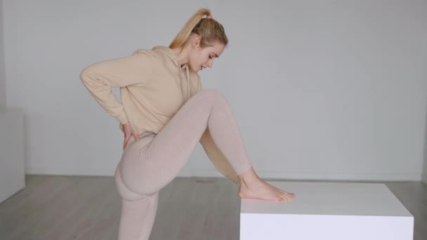 Passar kvinnlig atlet stretching ben nära kub — Stockvideo