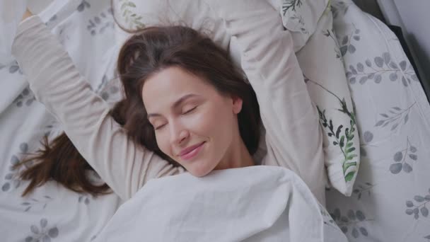 Glad kvinna sträcker ut armarna på sängen — Stockvideo
