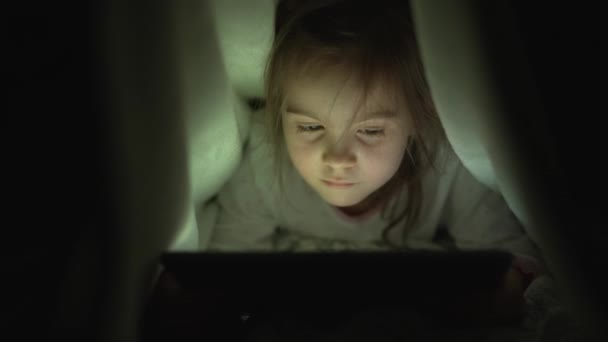 Κορίτσι που βλέπει φιλμ στο τάμπλετ τη νύχτα — Αρχείο Βίντεο