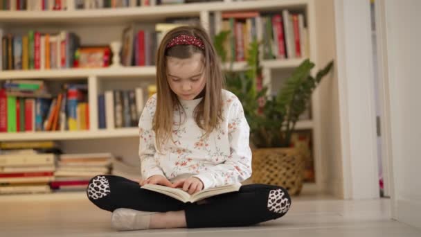 Маленька дитина читає книгу вдома — стокове відео