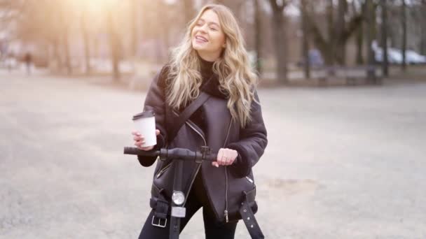 Lycklig kvinna med kaffe att gå på skoter — Stockvideo