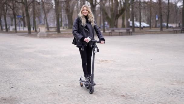 Lycklig kvinna på skoter höja benet — Stockvideo