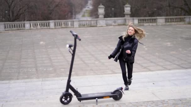 Elektrikli scooter 'a doğru koşan keyifli kadın — Stok video