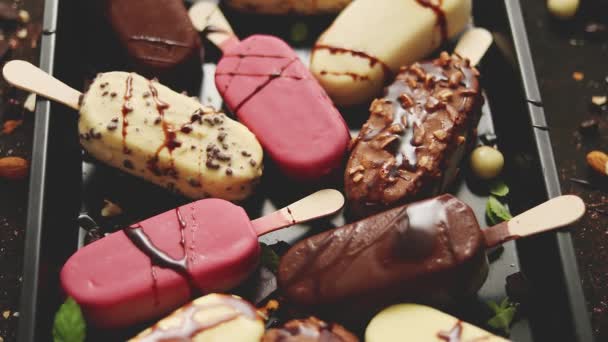 Sorvete no pau revestido com vários esmaltes de chocolate e coberturas. Vista superior, flat lay — Vídeo de Stock