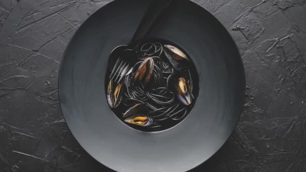 Fructe de mare paste de spaghete negre cu scoici servite pe placa neagra pe piatra intunecata — Videoclip de stoc