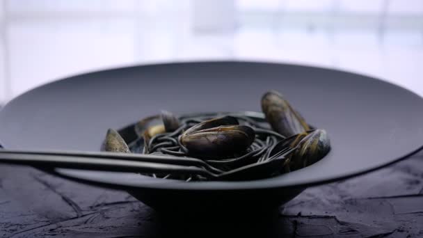 Spaghetti neri di mare con vongole serviti su piatto nero su pietra scura — Video Stock