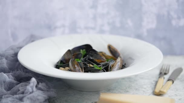 Pasta de espaguetis de mariscos negros con mejillones sobre fondo de piedra. Mediterránea deliciosa comida — Vídeo de stock