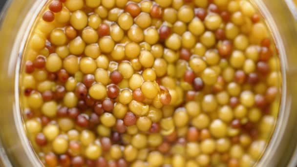 Mostarda francesa com sementes inteiras servidas em jarra de vidro. Foco seletivo — Vídeo de Stock