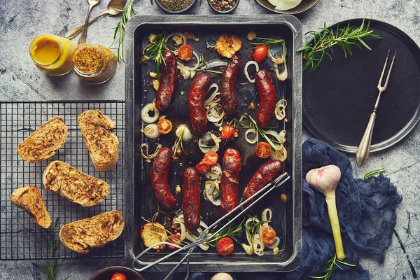 Délicieuses saucisses grillées servies sur un plateau en métal rouillé. Avec des légumes grillés — Photo