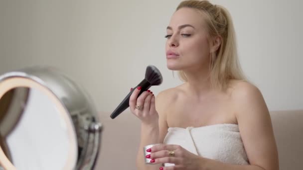 Blond vrouw aanbrengen van make-up in de ochtend — Stockvideo