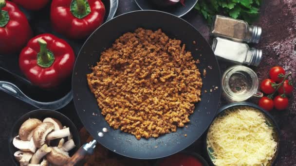 Ingrediënten op een tafel bereid voor het vullen van pepers. Rode paprika 's, gehakt, kaas — Stockvideo