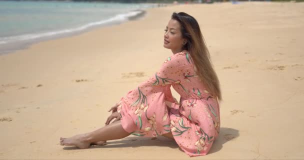 Mujer étnica descalza sentada en la playa — Vídeo de stock